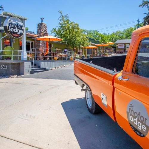 an orange pick up truck parked in front of a restaurant at The Motor Lodge in Prescott