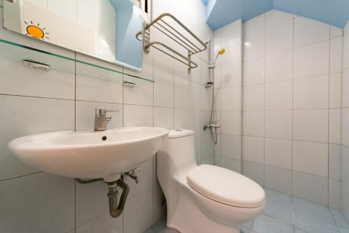 a bathroom with a white toilet and a sink at Sun B&B in Taitung City