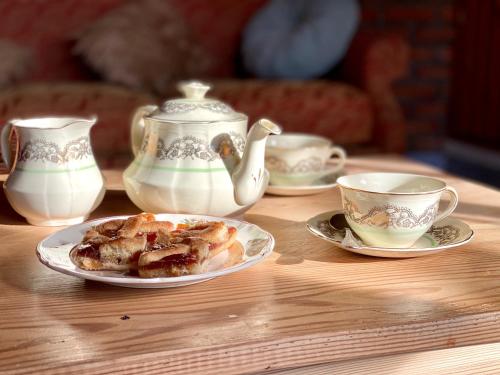 a table with a plate of food and cups on it at Estancia Bonanza Patagonian Lodge Experience in El Chalten