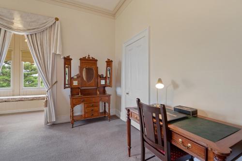 a room with a desk and a clock and a window at Waratah On York in Launceston