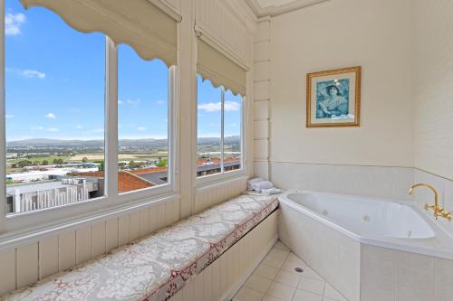 a bathroom with a tub and a large window at Waratah On York in Launceston