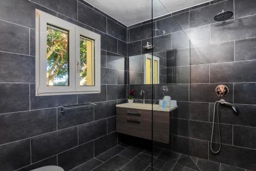 La salle de bains noire est pourvue d'un lavabo et d'une douche. dans l'établissement Doudou, à Dénia