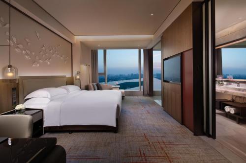 ein Schlafzimmer mit einem großen weißen Bett und einem TV in der Unterkunft InterContinental Quanzhou, an IHG Hotel in Quanzhou