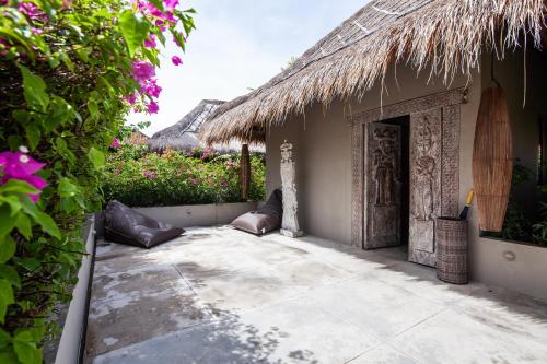 an entrance to a building with a thatch roof at Blue Karma Dijiwa Seminyak in Seminyak