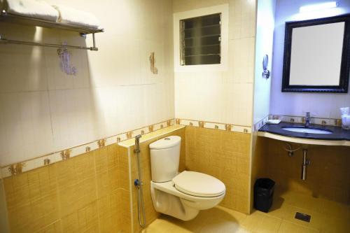 a bathroom with a toilet and a sink at Taz Kamar Family Hotel in Chennai