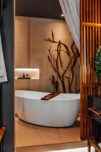 a bath tub in a bathroom with a tree mural at CASA EMILIA B&B Boutique in Mexico City