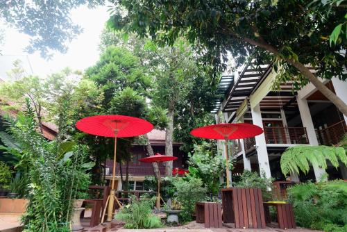 a group of red umbrellas in front of a building at บ้านเวียงเหล็ก Baan Veanglhek Residence in Phra Nakhon Si Ayutthaya