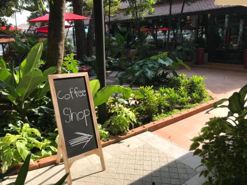 a sign that says coffee shop in a garden at Baan Veanglhek Residence in Phra Nakhon Si Ayutthaya