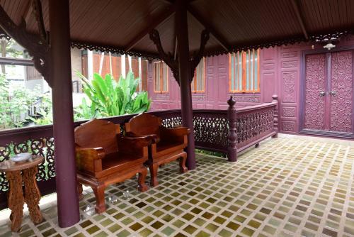 a living room with purple walls and a piano at Baan Veanglhek Residence in Phra Nakhon Si Ayutthaya