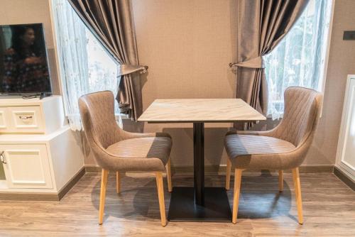 a table with two chairs and a table with a table at Baan Veanglhek Residence in Phra Nakhon Si Ayutthaya
