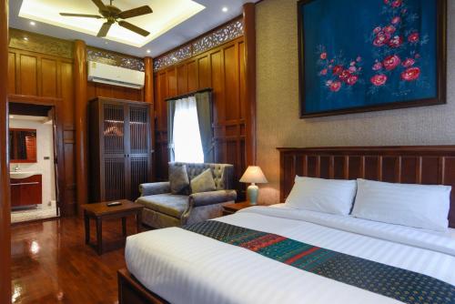 a hotel room with a bed and a chair at Baan Veanglhek Residence in Phra Nakhon Si Ayutthaya
