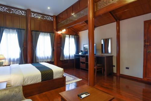 a bedroom with a bed and a desk in a room at Baan Veanglhek Residence in Phra Nakhon Si Ayutthaya
