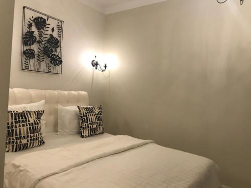 a white bedroom with a bed with two pillows at Luxury Old Town apartment in Vilnius