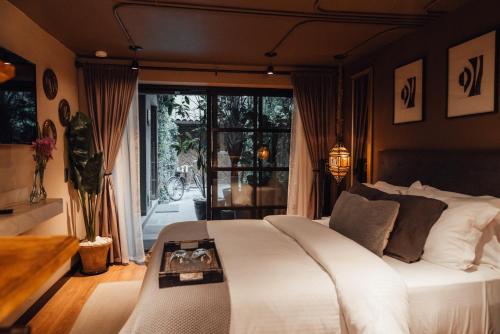 a bedroom with a white bed and a large window at CASA EMILIA B&B Boutique in Mexico City