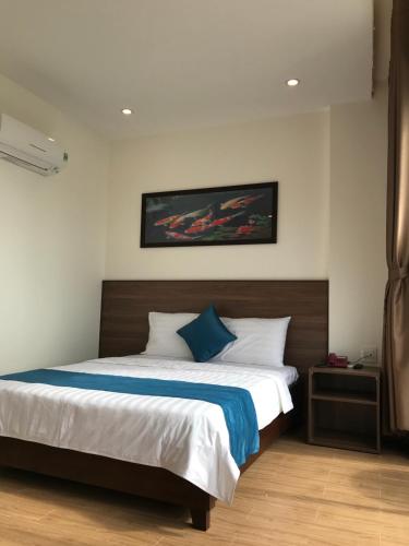 a bedroom with a large bed with a blue pillow at Hotel Hoàng Hưng Quy Nhơn in Quy Nhon