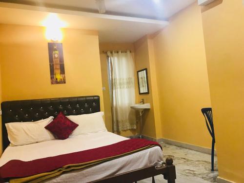 a bedroom with a bed with a black headboard at Royal Palace Marina in Chennai