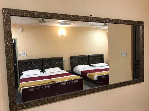a mirror reflecting three beds in a room at Royal Palace Marina in Chennai