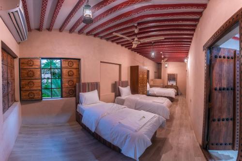 a room with three beds in a room with at نزل البستان Bustan lnn in Nizwa