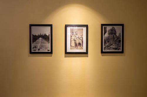 a group of pictures on a wall at Botum Palace Hotel in Phnom Penh