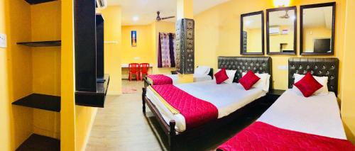 a bedroom with two beds with red pillows at Royal Palace Marina in Chennai