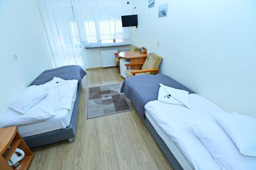 a small room with a bed and a desk at Ośrodek Konferencyjno-Wypoczynkowy "Posejdon" w Ustce in Ustka