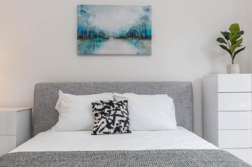 a bedroom with a bed with a gray headboard at Lofts du Parc LaHaie in Montréal