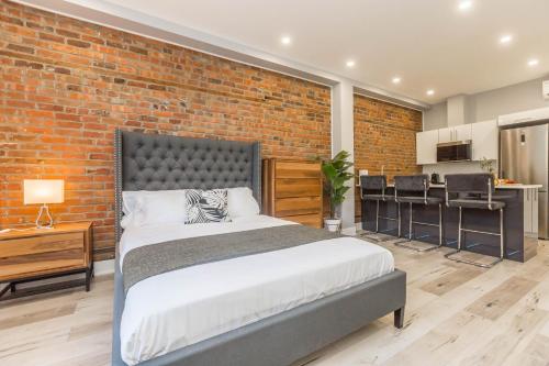 a bedroom with a large bed and a brick wall at Lofts du Parc LaHaie in Montréal