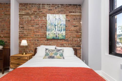 a bed in a room with a brick wall at Lofts du Parc LaHaie in Montréal