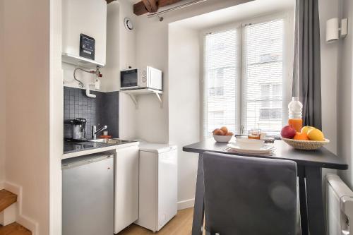une cuisine avec un comptoir noir et une fenêtre dans l'établissement Charming Duplex Studio in the heart of Paris, à Paris