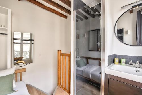 une salle de bain avec un lavabo et un miroir dans l'établissement Charming Duplex Studio in the heart of Paris, à Paris