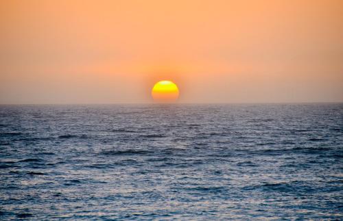 a sunset over the ocean with the sun setting at Cozy Getaway in Priory