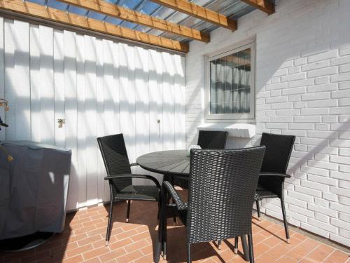 a table and chairs on a patio with a window at 4 person holiday home in Gr sten in Gråsten