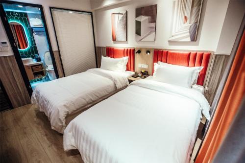 two beds sitting next to each other in a hotel room at Shanghai Fish Inn People Square in Shanghai