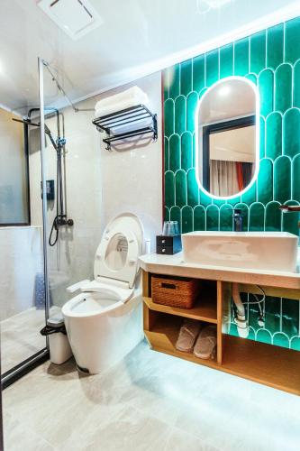 a bathroom with a toilet and a sink and a mirror at Shanghai Fish Inn People Square in Shanghai