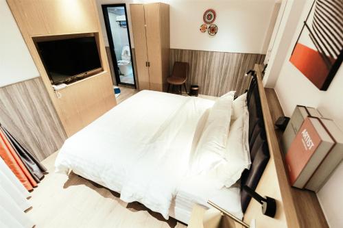 a bedroom with a white bed and a television at Shanghai Fish Inn People Square in Shanghai