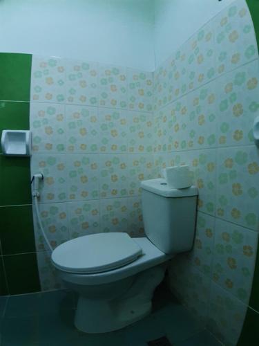 baño con aseo blanco en una habitación en OYO 671 Natua's Cabin, en Puerto Princesa City