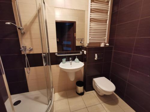 W łazience znajduje się umywalka, toaleta i prysznic. w obiekcie Wrzosowy Resort Pogorzelica Apartament PERŁOWY Sea&Forest w Pogorzelicy