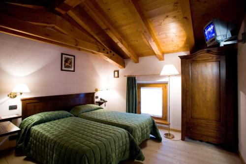 a bedroom with a bed with a green comforter at Agriturismo Al Casale in Codroipo