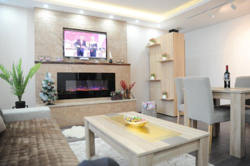 un soggiorno con TV sopra il camino di Apartman Kalina Suncani Breg a Kopaonik