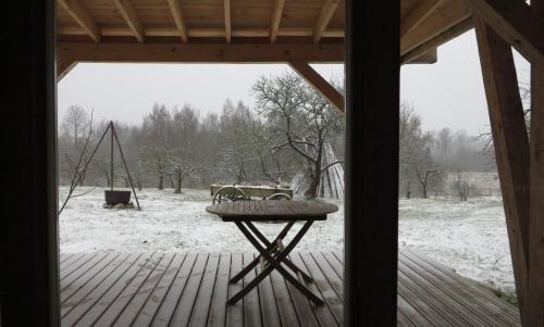 a view of a porch with a table and a playground at Mednieki Kalvene in Krusāti