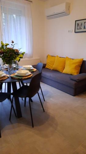 un soggiorno con divano e tavolo con cuscini gialli di Molo Wellness Garden a Siófok