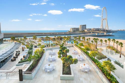an aerial view of a beach with tables and palm trees at Address Beach Resort in Dubai
