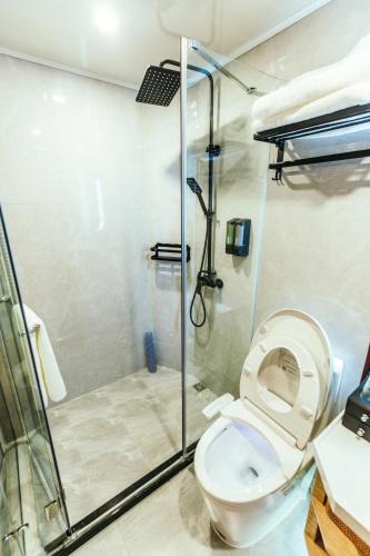 a bathroom with a shower and a toilet at Shanghai Fish Inn People Square in Shanghai