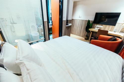 a bedroom with a large white bed and a desk at Shanghai Fish Inn People Square in Shanghai