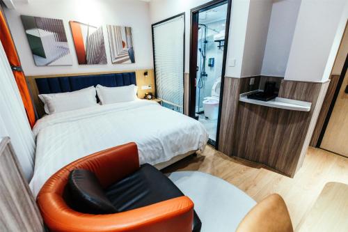 a bedroom with a bed and a chair and a bathroom at Shanghai Fish Inn People Square in Shanghai
