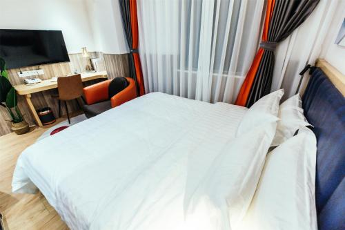 a bedroom with a white bed and a desk with a computer at Shanghai Fish Inn People Square in Shanghai