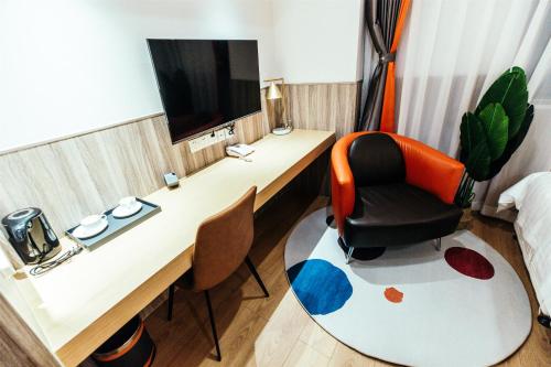 a room with a desk with a chair and a television at Shanghai Fish Inn People Square in Shanghai