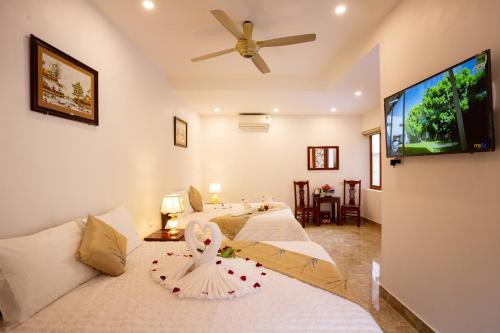 a bedroom with two beds and a flat screen tv at Lys Homestay in Ninh Binh