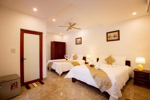 a bedroom with two beds and a ceiling fan at Lys Homestay in Ninh Binh