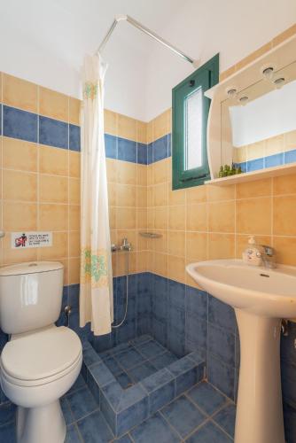 a bathroom with a toilet and a sink at Naftilos Studios in Lourdata